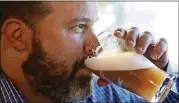  ?? CURTIS COMPTON/CCOMPTON@AJC.COM ?? Rep. Kasey Carpenter (R-Dalton) samples his Space Force IPA, a teakwood-colored beer with citrus overtones. It was meant to mimic the Five Killer Citrus IPA that he produces at his Cherokee brewpub in Dalton.