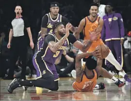  ?? Kevork Djansezian Getty Images ?? ANTHONY DAVIS battles for the ball with Cameron Payne of the Suns during the first half at Staples Center. Phoenix pulled away in the second quarter.