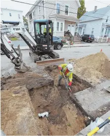  ?? STAFF PHOTO BY MATT STONE ?? DIGGING IN: Columbia Gas workers inspect and repair gas lines in Lawrence yesterday.