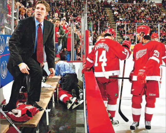  ?? JULIAN H. GONZALEZ/ AP ?? A worried Detroit Red Wings coach Mike Babcock steps on to the bench as team physician Dr. Tony Colucci, background, performs CPR on stricken defenceman Jiri Fischer.