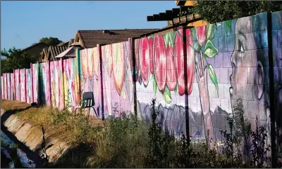  ?? ?? A mural runs along the length of a retaining wall at the community garden.