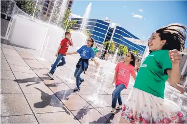  ?? ROBERTO E. ROSALES/JOURNAL ?? Members of the Boys and Girls Club play in the interactiv­e fountain at the unveiling of the Civic Plaza redesign project Saturday afternoon.