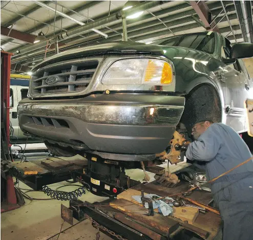  ?? RICK MACWILLIAM / POSTMEDIA NEWS ?? Mechanic Frank Jansen works on a Ford pickup at Art Barry Ford in Edmonton.