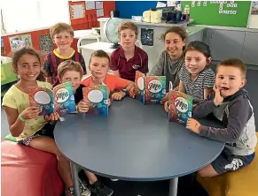  ?? JAMIE SEARLE/STUFF ?? Myross Bush School pupils check out This Is Me, journal for kids, clockwise from left, Lily Tufui, Benji McDonald, Jonty McDonald (standing), Ryan Hill, Cooper McDonald, Hannah Tufui, Daisy McDonald and Leon Hill.