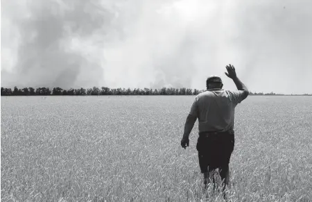  ?? EFREM LUKATSKY AP ?? A farmer reacts after his field was set on fire by the fighting in the Dnipropetr­ovsk area of Ukraine on Monday.