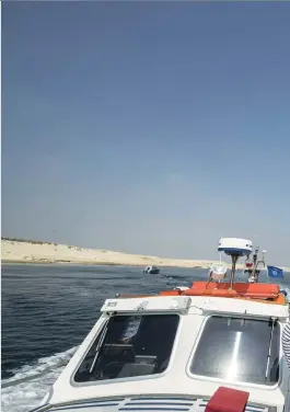  ??  ?? Right: A container ship sails through the new section of the Suez Canal.