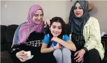  ?? LEAH HENNEL ?? Syrian refugees Seham Talab with two of her four children Najat Al Masalmeh, middle and Yasmin Al Masalmeh, worry for their family in the United States.