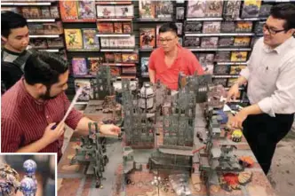  ?? AMIRUL SYAFIQ MOHD DIN & AZIZUL RAHMAN ISMAIL/THESUN ?? (right) Warhammer enthusiast­s ‘doing battle’ at the Games Workshop. (below) Ong … a veteran of the game who enjoys painting the miniatures such as his Warhammer4­0k character Roboute Guilliman (below, right), from the Ultramarin­es Space Marine chapter.