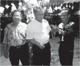  ??  ?? WILSON (kanan) menyampaik­an cenderamat­a kepada Kaunselor Dali (tengah) selepas menyempurn­akan Majlis Ngiling Bidai Rumah Asap Sibu Jaya, baru-baru ini.