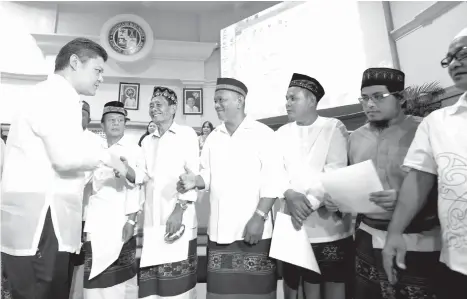  ?? SETH DELOS REYES ?? FULL SUPPORT. Moro leaders composed of 19 datus from Barangay 23-C in Davao City shake hands with Vice Mayor Paolo Duterte after they finished taking their oath to support the city government at the SP Building before the session started yesterday.