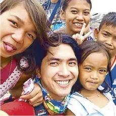  ??  ?? Josh Mahinay with children from Isla Pulo, Navotas (above). Volunteers carry new bags ready to bring joy and hope to deserving students (above right).