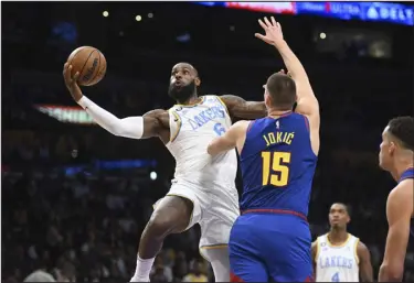  ?? MICHAEL OWEN BAKER— THE ASSOCIATED PRESS ?? Los Angeles Lakers forward Lebron James goes to the basket against Denver center Nikola Jokic during the first half on Sunday in Los Angeles.
