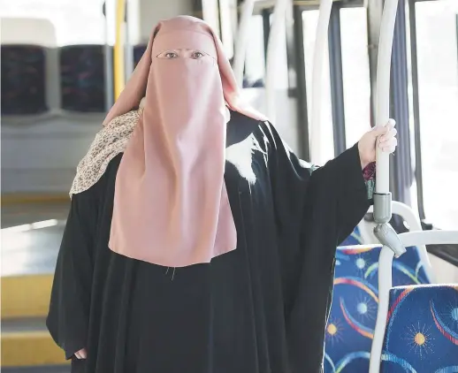  ?? − La Presse canadienne: Graham Hugues ?? Warda Naili pose pour une photo dans un autobus de Montréal, récemment.