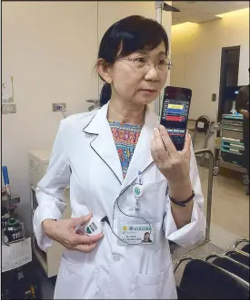  ??  ?? Nina Kao, CEO of Changua Hospital Group’s Overseas Medical Mission Center shows how the patient’s vital signs are automatica­lly transmitte­d to a nurse’s mobile phone.