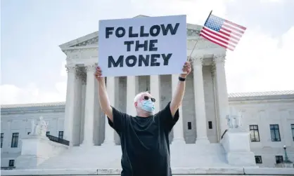  ?? Photograph: Jim Lo Scalzo/EPA ?? ▲ A man protests outside the supreme court in Washington during a case about releasing Donald Trump’s tax returns this summer.