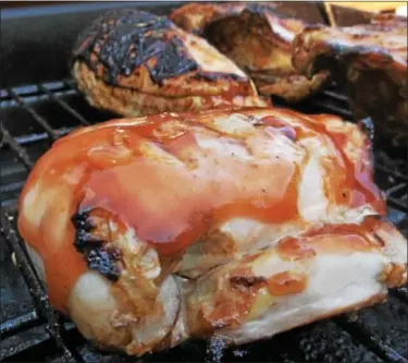  ?? PHOTO BY JIM BAILEY ?? Blood Orange Huli Huli Chicken cooks on a grill.