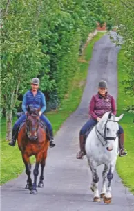  ??  ?? “We do lots of hacking,” says Polly, pictured on Randalstow­n Cromwell (right) with staff groom Shelley Catch on Banview Sirocco