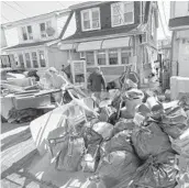  ?? MARK LENNIHAN/AP ?? People clear damaged belongings from their homes Sept. 3 in the Queens borough of New York. Many Northeaste­rn residents didn’t have flood insurance.