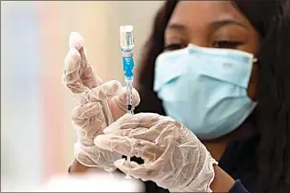  ?? DAMIAN DOVARGANES / AP FILE ?? In this March 11 photo, a health worker loads syringes with the vaccine on the first day of the Johnson & Johnson vaccine being made available to residents at the Baldwin Hills Crenshaw Plaza in Los Angeles.