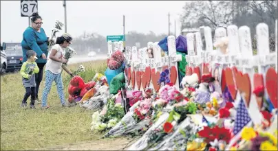  ?? AP PHOTO ?? Christina Osborn and her children Alexander Osborn and Bella Araiza visit a makeshift memorial for the victims of the shooting at Sutherland Springs Baptist Church, Sunday in Sutherland Springs, Texas. A man opened fire inside the church in the small...