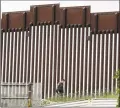  ?? Gregory Bull / Associated Press file photo ?? In this March 18 photo, a Border Patrol agent walks along a border wall separating Tijuana, Mexico, from San Diego.