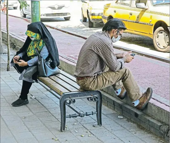  ?? ATTA KENARE / AFP ?? Los iraníes, como esta pareja en el centro de Teherán, sufren una grave crisis económica, agravada por las sanciones de EE.UU.
