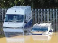  ??  ?? Cars caught in flood water after Storm Callum passed through the town of Carmarthen, west Wales.