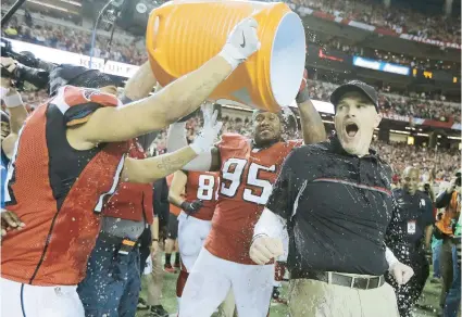  ??  ?? El head coach de los Falcons de Atlanta, Dan Quinn recibe el tradiciona­l baño tras ganar el cetro de su conferenci­a.