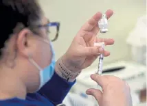  ?? Don Campbell, The Herald-Palladium via The Associated Press ?? Registered medical assistant Jennifer Roberts prepares a dose of the Moderna vaccine during a COVID-19 vaccine clinic on Friday in Benton Harbor, Mich.