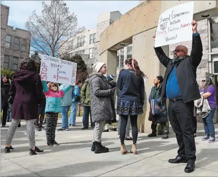  ?? SARAH GORDON/THE DAY ?? Luis Rodriguez, associate director of the Holleran Center, holds a sign saying “Shared governance must include dining, facilities, admin voices” as Connecticu­t College staff members gather outside Harris Dining Hall to support student and faculty protests Wednesday.