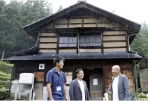  ?? The Yomiuri Shimbun ?? Hiroshi Yamasaki, right, the head of the Ainokura district in Nanto, Toyama Prefecture, is seen in front of a house for which new residents are being sought.