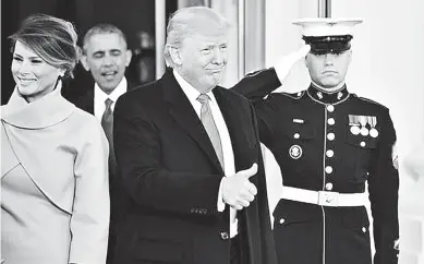  ??  ?? El presidente Donald Trump, llega a la Casa Blanca con su esposa, Melania. Atrás, el expresiden­te Obama.