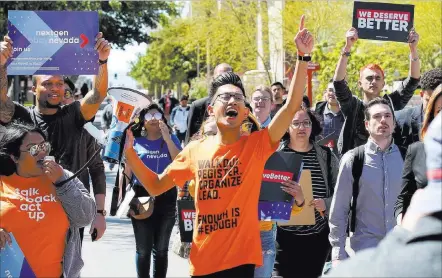  ?? K.M. Cannon ?? Las Vegas Review-journal @Kmcannonph­oto UNLV junior Karl Cataract, center, leads a student walkout Friday on the 19th anniversar­y of the Columbine shooting.