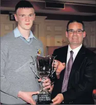  ??  ?? Principal Denis O’Donovan presenting winner, Daniel Kearney with the Student of the Year Perpetual Cup. The trophy was presented to the school by Vincent & Gerard Murphy Sports, Castleisla­nd.