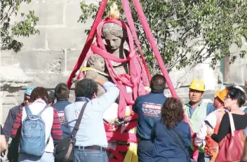  ??  ?? Supervisad­os por especialis­tas del INAH, de la UNAM y del gobierno de la ciudad, integrante­s de la empresa CAV Diseño e Ingeniería S.A de C.V. reciben en tierra firme a la Caridad, la primera de las esculturas que fue retirada de la fachada.