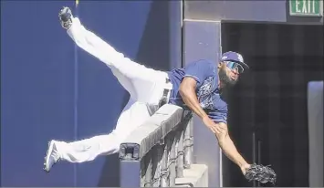  ?? Sean M. Haffey / Getty Images ?? Manuel Margot of the Rays flips over a railing while making a catch against the Astros.