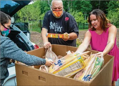  ?? PHIL SKINNER FOR THE ATLANTA JOURNAL-CONSTITUTI­ON ?? Heather Moon (left to right) and Jason Creed help Goode Van Slyke Architectu­re marketing coordinato­r Crystal Genter unload donations from her car at the Atlanta Community Food Bank in East Point. The firm is celebratin­g its silver anniversar­y by committing to 25 good deeds.