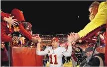  ?? ALEX BRANDON/ASSOCIATED PRESS ?? Alex Smith (11) celebrates with fans after a game against the Dallas Cowboys in October of 2018. He announced his retirement Monday on Instagram.