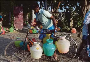  ?? AFP PIC ?? A man carrying plastic pots of drinking water on his bicycle in Chennai on Thursday.