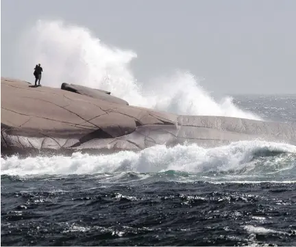  ?? ANDREW VAUGHAN/THE CANADIAN PRESS ?? Waves pound the rocks at Peggy’s Cove, N.S., a popular tourist spot where two men have died recently.