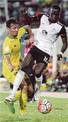  ?? [ FOTO ASWADI ALIAS / BH ] ?? Pemain T-team, Makan Konate (kanan) diasak pemain Kedah, Mohd Rizal Ghazali pada aksi Piala Malaysia di Stadium Sultan Ismail Nasiruddin Shah, malam tadi.