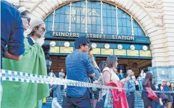  ?? FOTO: AFP ?? Passanten verfolgen die Rettungsar­beiten vor der Flinders Street Station in Melbourne.