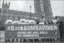  ?? CARL COURT, GETTY IMAGES ?? Workers from the Bombardier factory in Belfast and supporters hold a banner to highlight their concern about job losses in London.