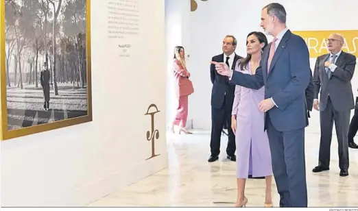  ?? ANTONIO MONTIEL ?? Los Reyes de España ante el retrato de Pío Baroja paseando por el Retiro de la exposición con fotografía­s de la RAE.