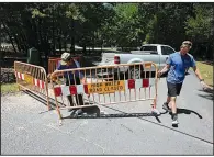  ?? Arkansas Democrat-Gazette/THOMAS METTHE ?? Junior Upchurch (left) and Thomas Meares of the Conway Parks and Recreation Department put up barriers Friday to close Cadron Settlement Park as water continues to rise on the Arkansas River.