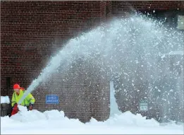  ?? Mark Stockwell/The Sun Chronicle via AP ?? A custodian at the Vincent Igo Elementary School in Foxboro, Mass. clears snow from the school’s walkway Monday, after the area received well over a foot of snow in an overnight storm.