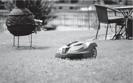  ?? [SARAH PHIPPS/ THE OKLAHOMAN] ?? A robotic mower moves around a yard Tuesday at a home in Arcadia.