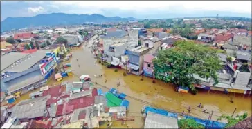  ?? THE JAKARTA POST ?? Residents wade through water on Dayeuhkolo­t Road, which became inundated with floodwater­s from the Citarum River in Bandung regency, West Java, Indonesia on March 7, 2019.