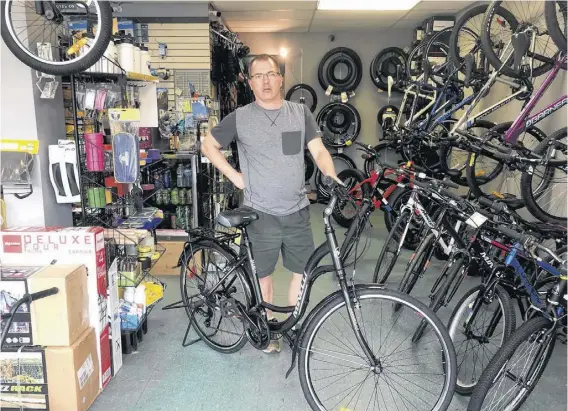  ?? CONTRIBUTE­D ?? Owner Basil Hicks shows off one of the bikes inside Bicycle Specialist & Sport in Amherst.