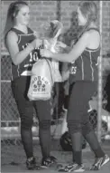  ?? MARK HUMPHREY ENTERPRISE-LEADER ?? Little sister, Jaycie Neeley (freshman), presents big sister, Alyssa Neeley (senior) with gifts as the Lincoln girls softball team celebrated senior night on Monday. The Lady Wolves overcame deficits three times to prevail in extra innings, 10-9, over...